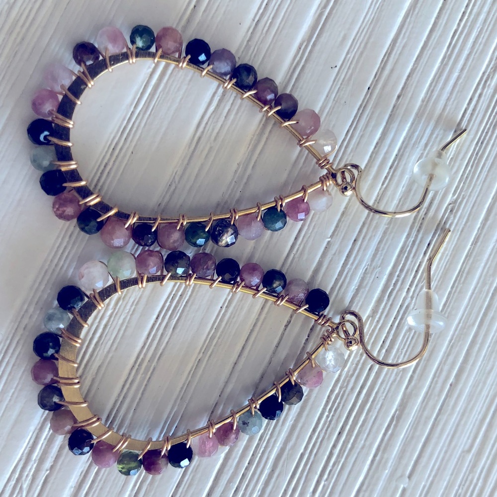 Beaded drop earrings against gold rim.